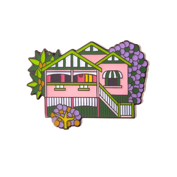 An enamel keyring featuring a pretty pink house surrounded by trees and flowers.