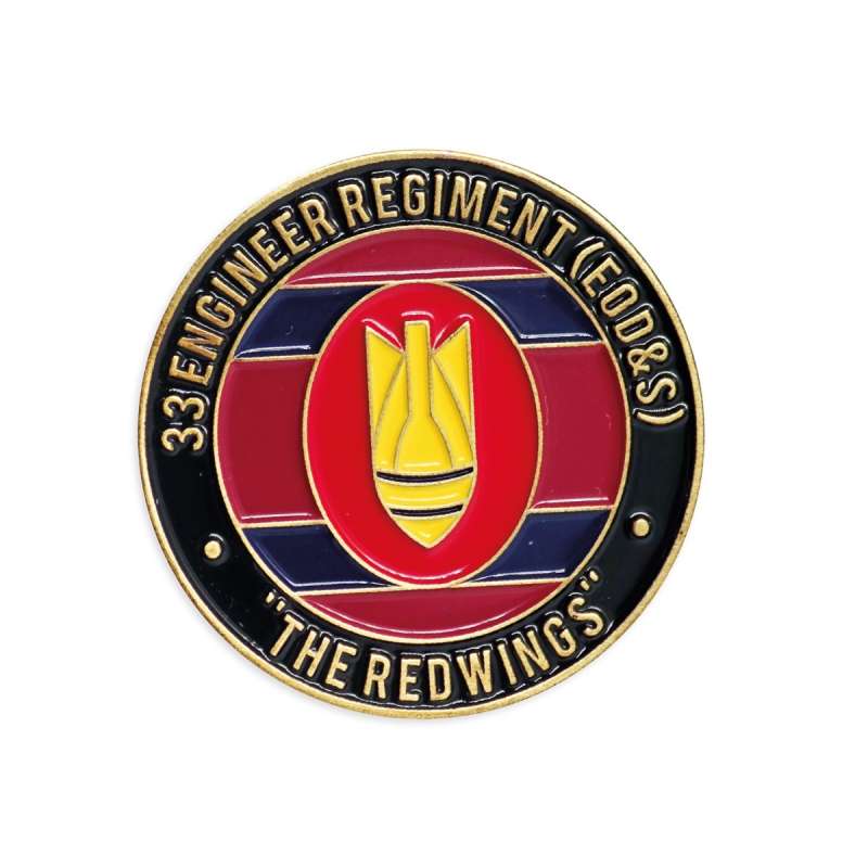 A red, black, and gold challenge coin commemorating the 33 Engineer Regiment.