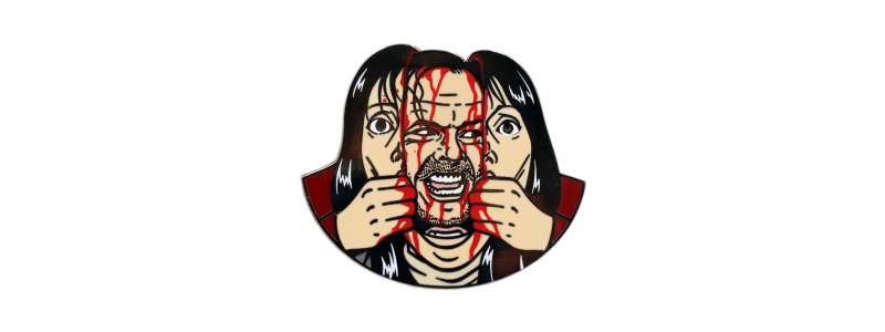 A pin badge of Jack Torrence from The Shining. Instead of bursting through the hotel door, he's bursting through his wife's face. He's covered in blood.