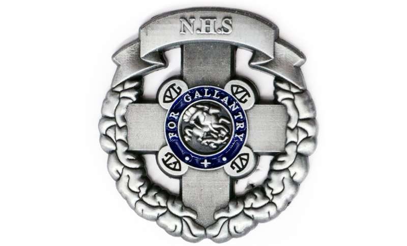 A replica enamel pin badge of the St George's Cross medal awarded to the NHS for dedicated and courageous service.