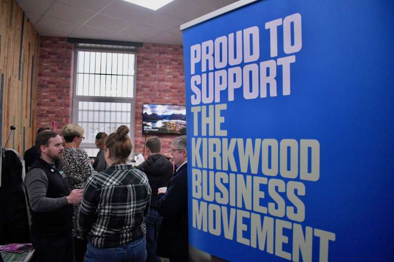 A meeting of local business leaders and a pull banner that reads 