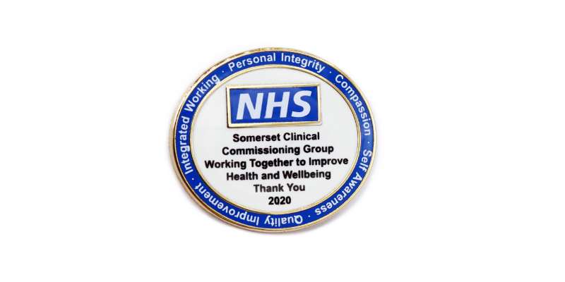 A blue and white NHS trust badge for department members to wear.