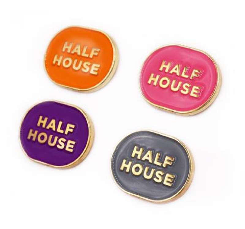 Four soft enamel badges with an oval shape and the words 