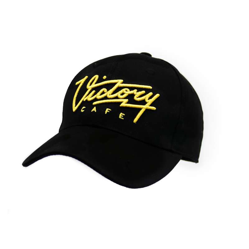 A black custom baseball cap with the Victory Cafe logo embroidered in gold.