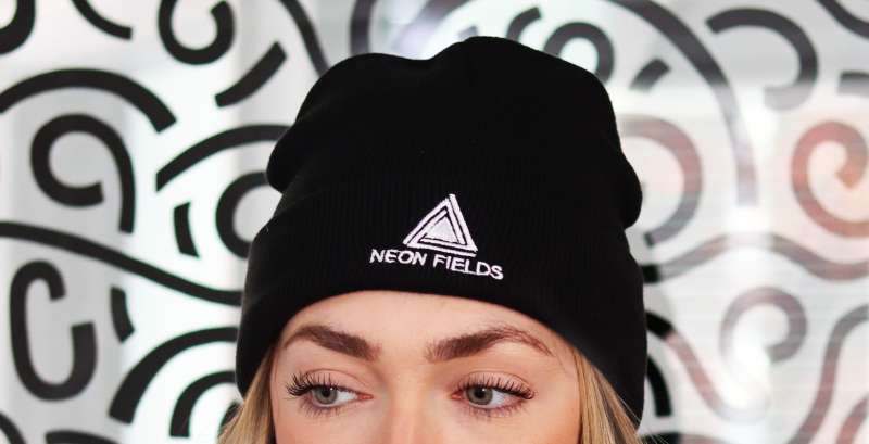 A black custom beanie with a white branded logo embroidered on the front.