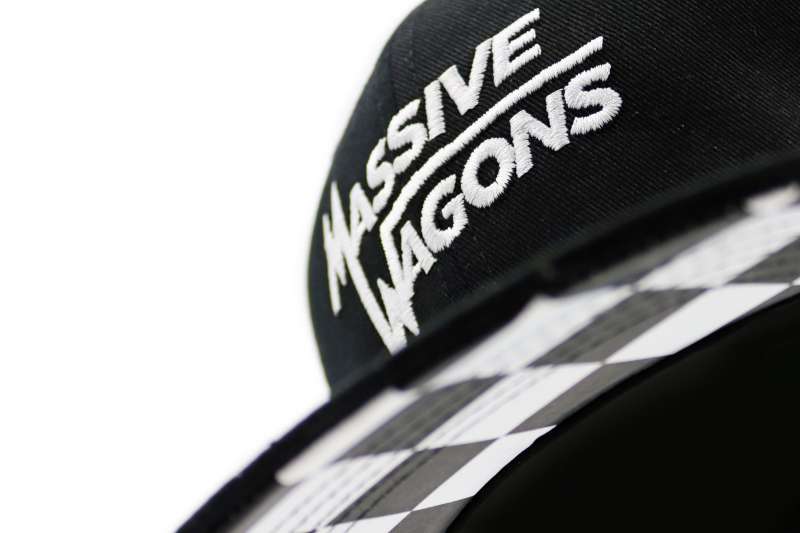 A close up of a black baseball cap with Massive Wagons embroidered on the front.