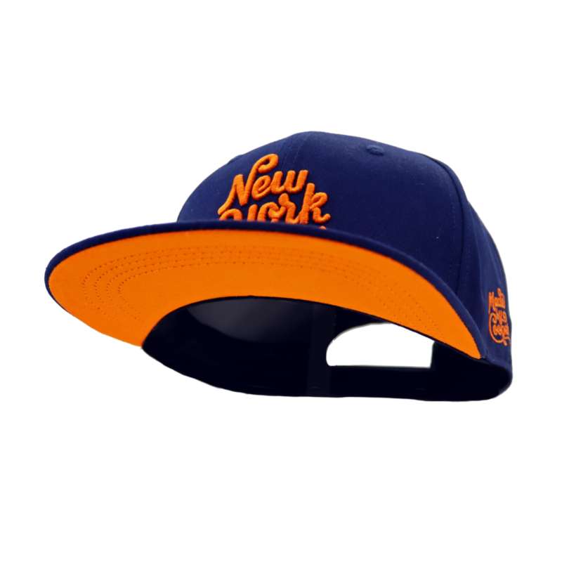 The underside of the brim of a blue baseball cap with orange New York embroidered logo. The underside of the peak is the same orange as the logo.