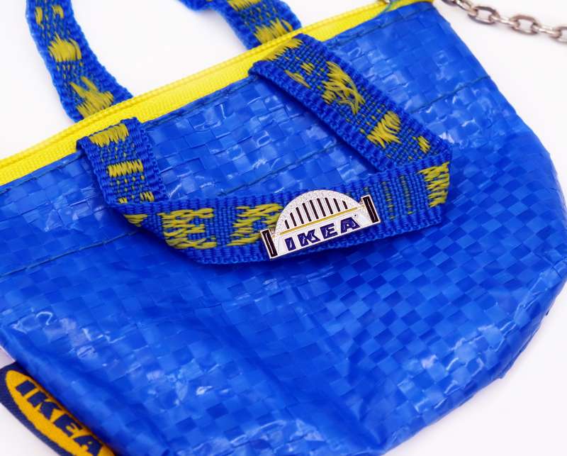A minature IKEA bag with a branded pin badge on the handle.
