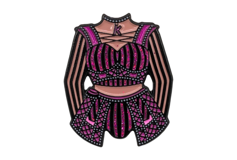 A pin badge of a burlesque costume with pink and black fabric and glitter enamel.