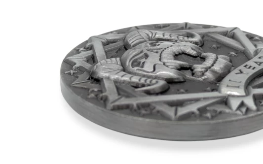 A close up of a custom challenge coin that shows the intricate details of a coin that has a satanic style design with a pentagram and horned skull.