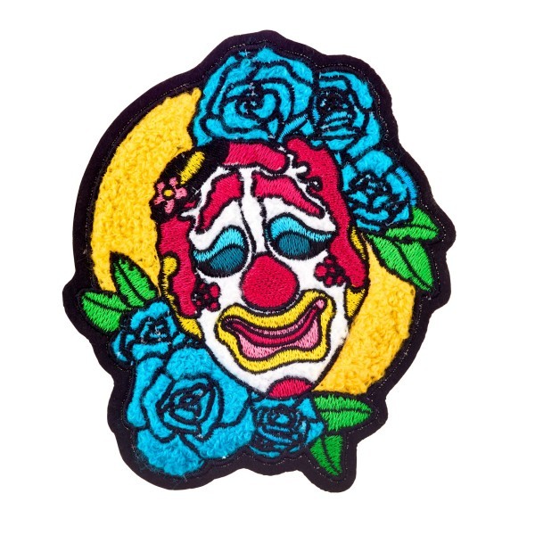 A brightly coloured chenille patch featuring a sad looking clown face and blue flowers.