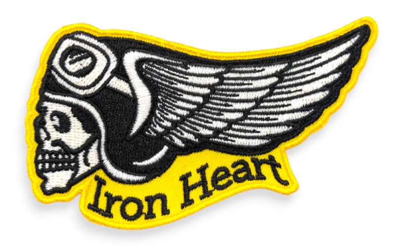 A yellow and black biker patch with a skull wearing a helmet with wings coming off the back of it. The words 