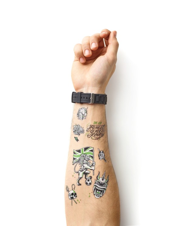 A hairy forearm wearing a sports watch. The hairy arm has plenty of temporary tattoos that are black and green.