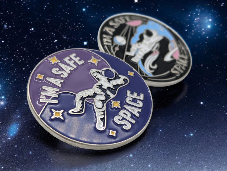Two custom trans pin badges featuring the logo for Stevie's Safe Space, an organisation that focuses on helping transgender people across the world.