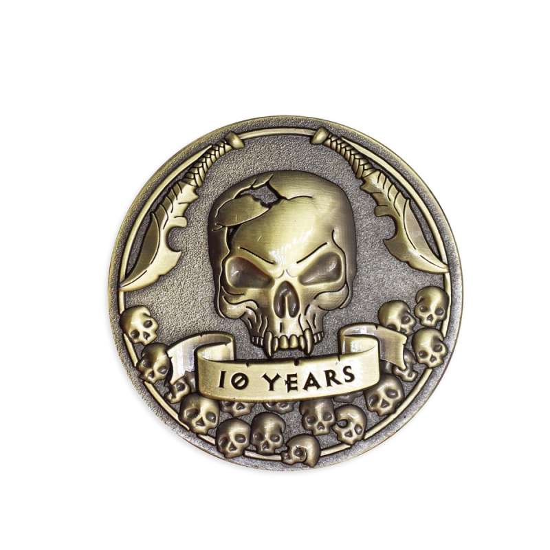 A gold-coloured custom coin featuring a menacing skull, two dangerous-looking knives and a banner that reads 