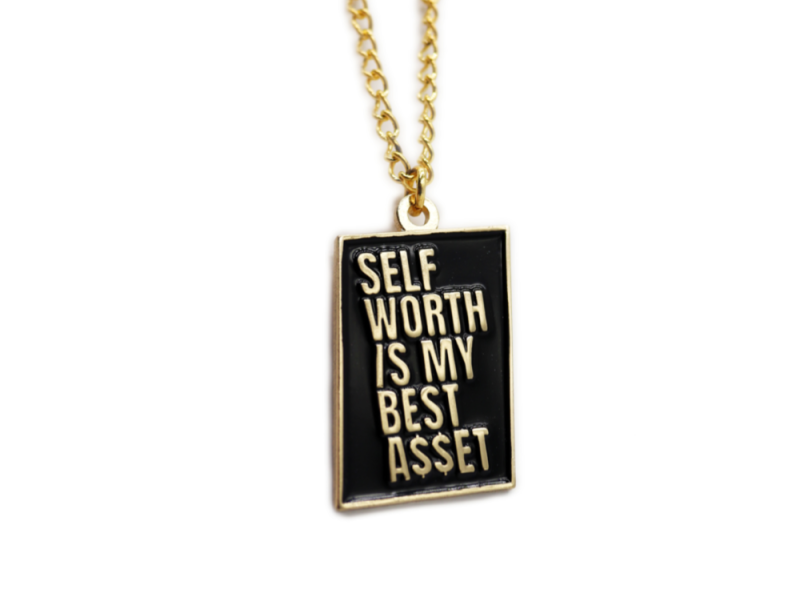 A gold chain and pendant with a black background. The gold text on the pendant reads