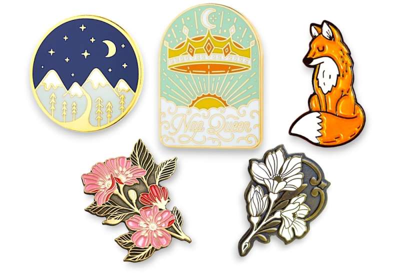 Collection of real enamel pin badges including mountain, crown, fox and floral designs showing clean manufacturable styles