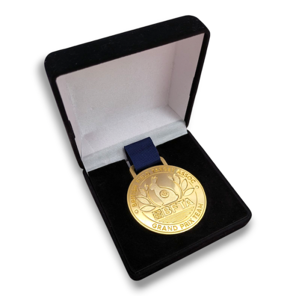 A gold plated custom field target medal in a velvet presentation box.