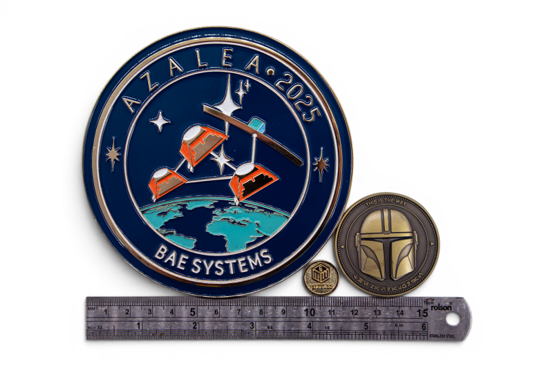 Large and small custom enamel coins beside a 15cm ruler, showing how different coin sizes compare at their longest edge.