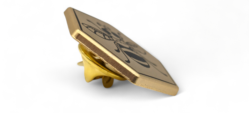 A gold-plated badge side on to demonstrate how a pin's thickness can add to a quality feel.