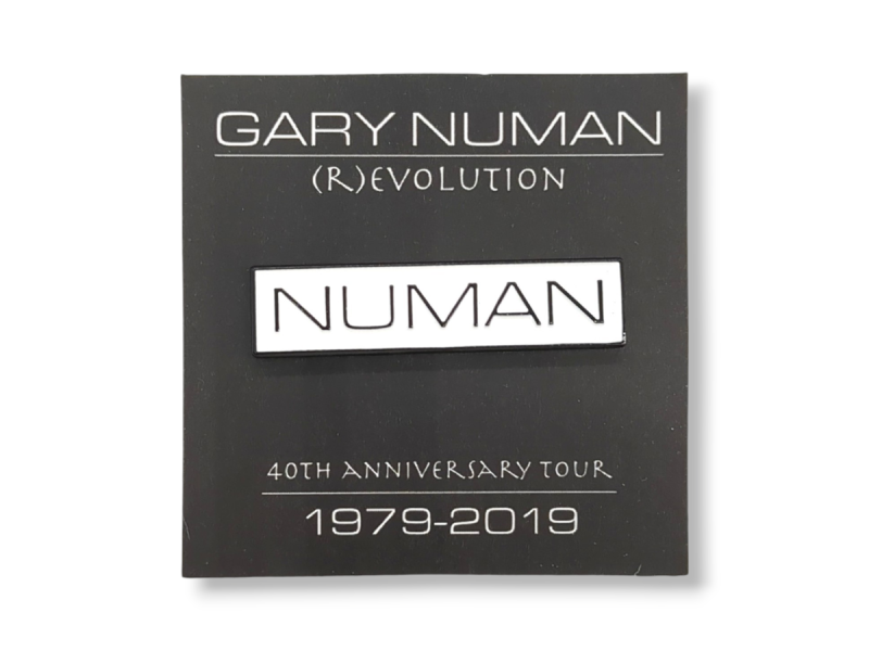 A Gary Numan soft enamel pin badge with a black backing card to celebrate his 40th anniversary in music.
