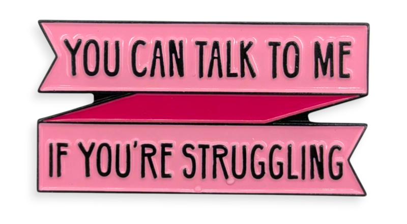 A pink banner pin badge with the words
