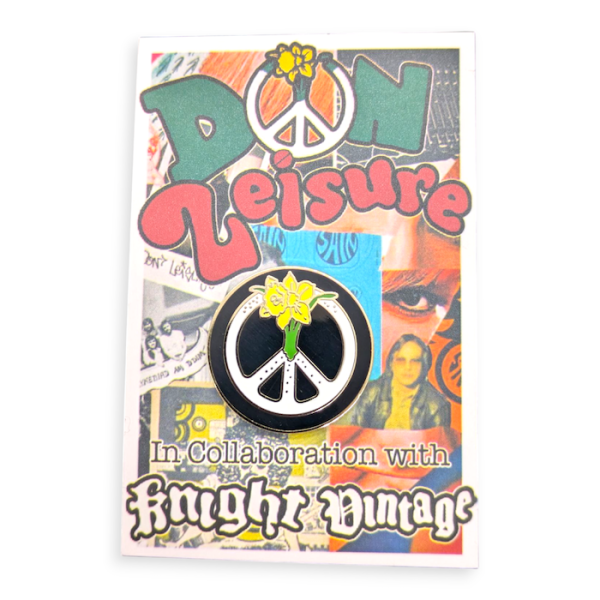 A CND logo hard enamel lapel pin and a multicoloured backing card.