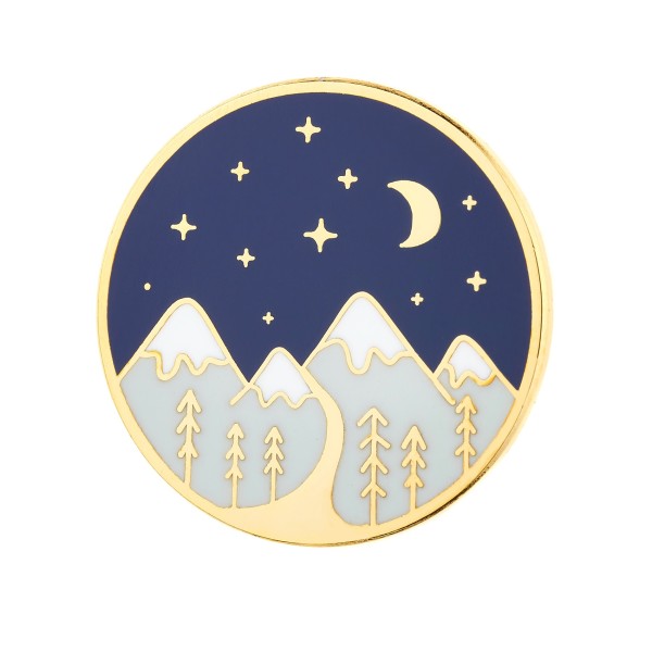 A circular pin badge with gold-plated edges. The design depicts a snow-topped mountain range, dark night sky, golden stars, and moon.