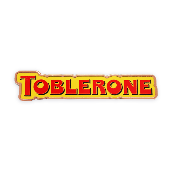 Hard enamel pin badge displaying the Toblerone logo in yellow and red with a smooth, flat enamel finish and crisp metal outline, produced as a bold branded pin badge.