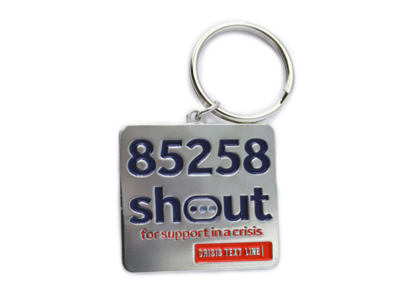 A square silver keyring with the logo for the Shout It Out charity organisation.