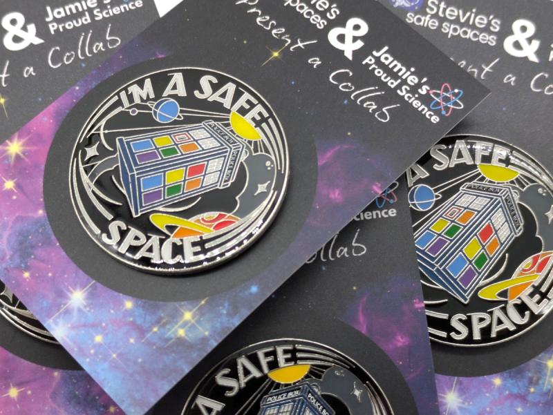 a huge pile of safe space tardis pin badges on backing cards stacked all willy nilly. it looks messy but artisitic.