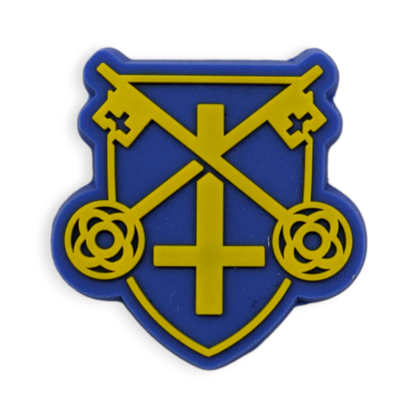 A blue shield shaped custom rubber pin badge. The shield has crossed keys and an upside down cross.