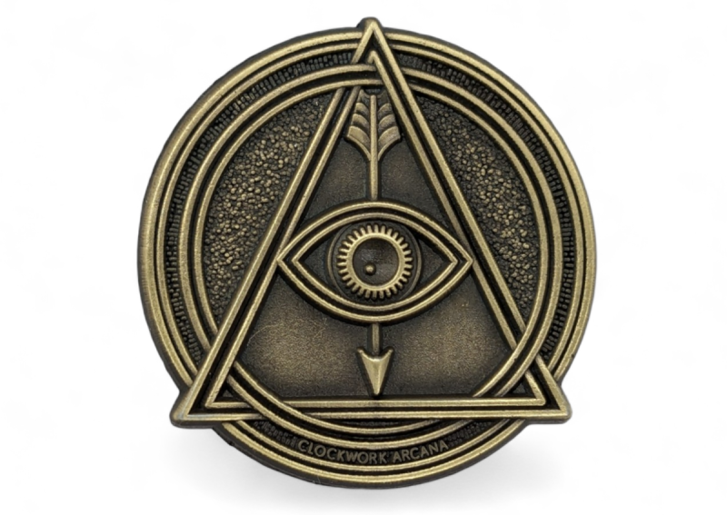 A circular gold-plated antiquing pin badge featuring the all-seeing eye.