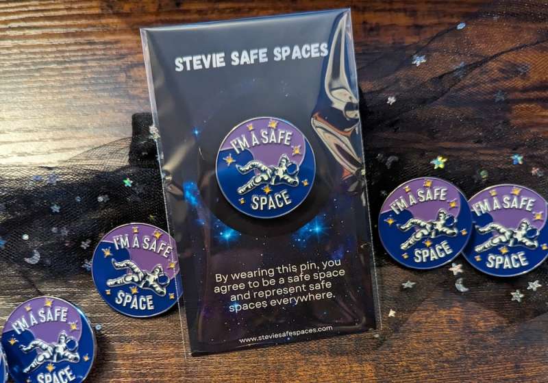 The purple and blue I'm a Safe Space pin badge on a backing card that reads