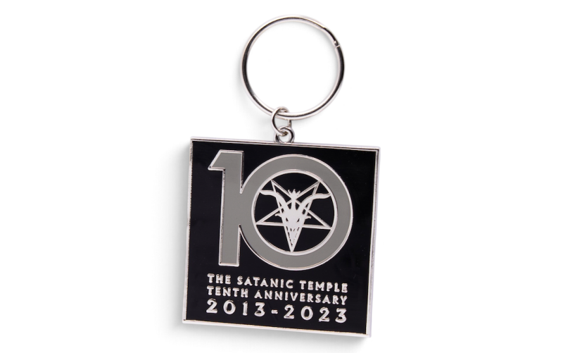 Square black and silver metal keyring commemorating The Satanic Temple's 10th anniversary, featuring a large 10 and 2013–2023 dates.