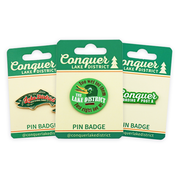 Soft enamel pins with Conquer Lake District designs, colourful enamel pin badges on branded backing cards with custom shapes and plating.