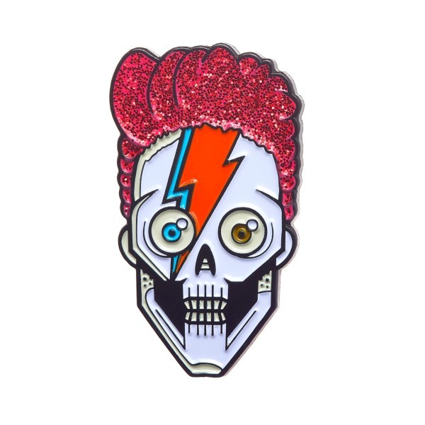 A custom soft enamel pin badge of a skull with red glitter hair and a David Bowie flash painted on his face.