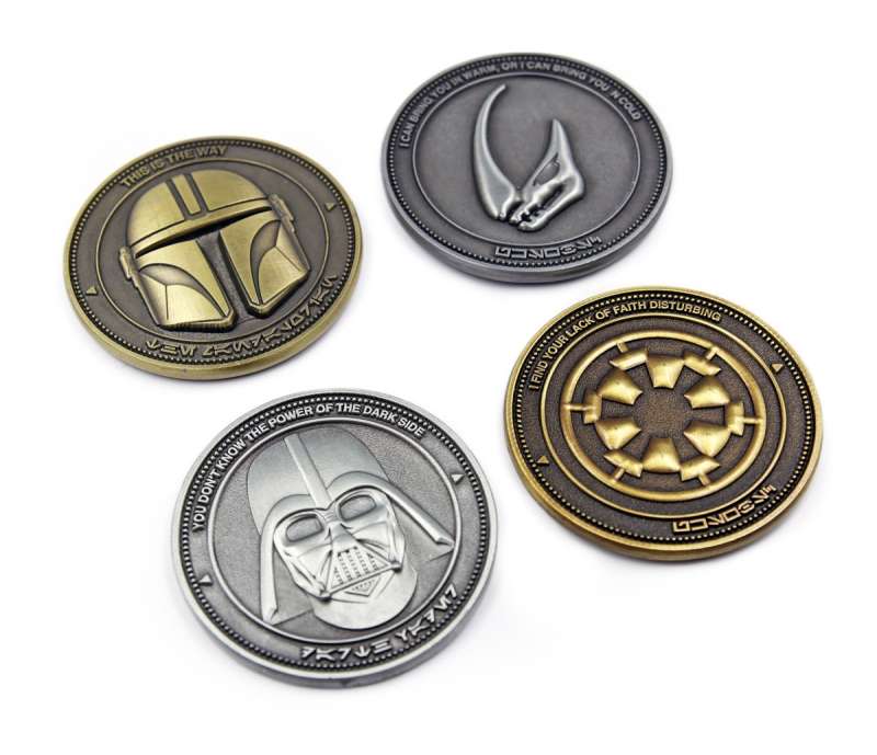 Custom challenge coins featuring the Star Wars characters Mando and Darth Vader. The coins have a silver and gold antiquing effect.