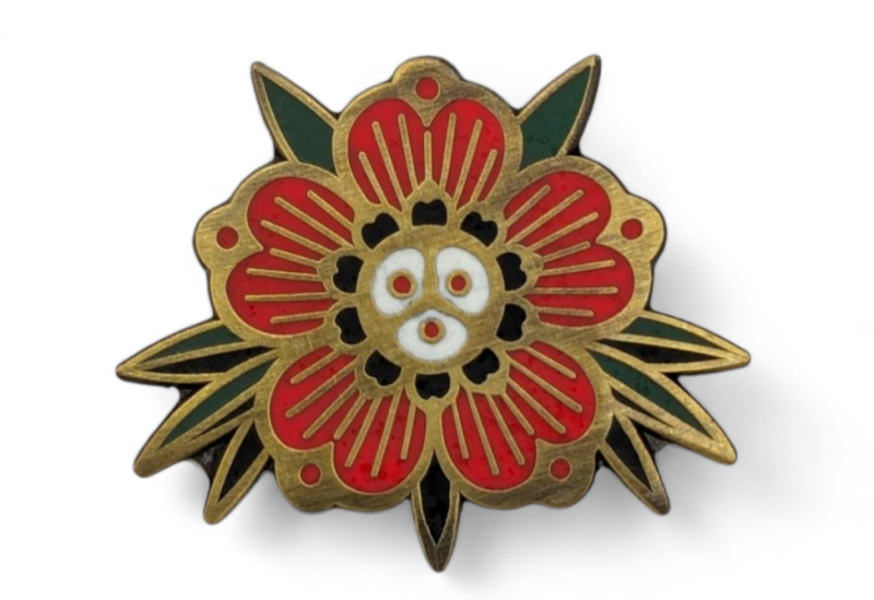 A vintage flower enamel pin with gold antique plating and red petals.