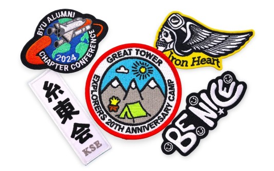 Collection of custom embroidered patches with bold colours and logos showing typical styles used for branding and identity.