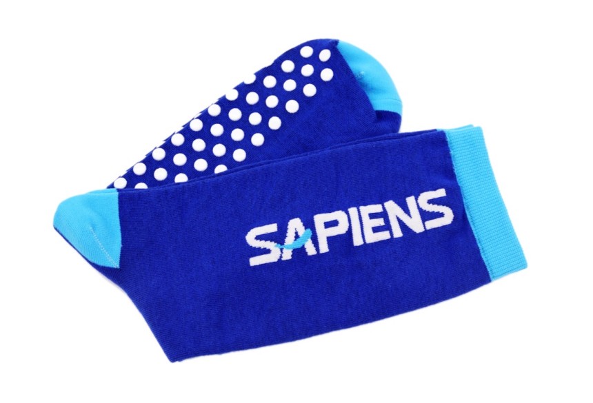A pair of royal blue grip socks have rubber soles with branding.