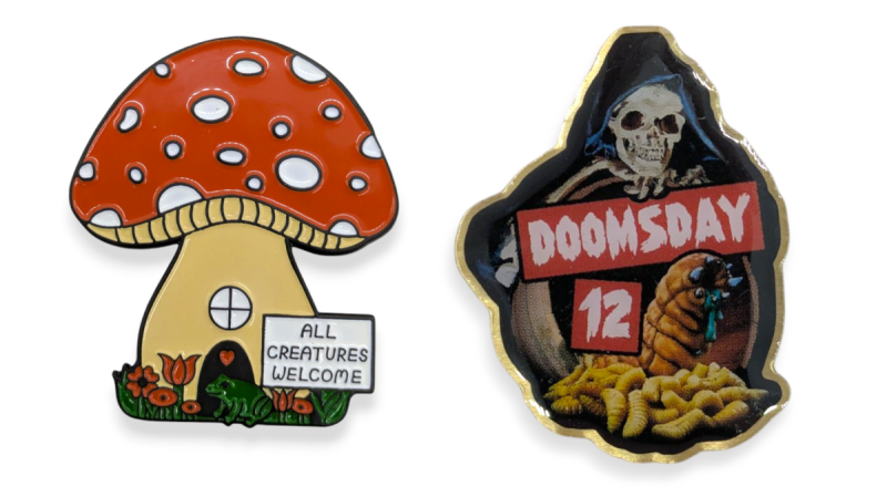 A comparison between a soft enamel and a printed pin badge. The soft enamel badge is a mushroom-shaped house, while the printed badge features the grim reaper holding a sign that says