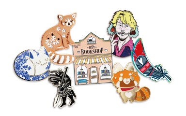 A collection of expensive looking pin badges including a sleeping cat, large book shop, a fox, a blue and red feather, a spear weilding wolf, and a dude smoking a cigarette. He looks shifty.
