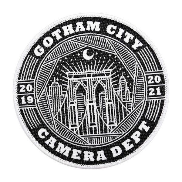 A circular custom patch featuring the skyscape of Gotham City with the words