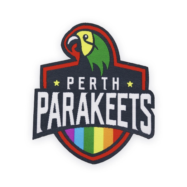 Shield shaped woven patch with Perth Parakeets text, parrot graphic and rainbow stripes, created as a bold custom woven patch for sports teams, clubs or inclusive branded woven patches UK.